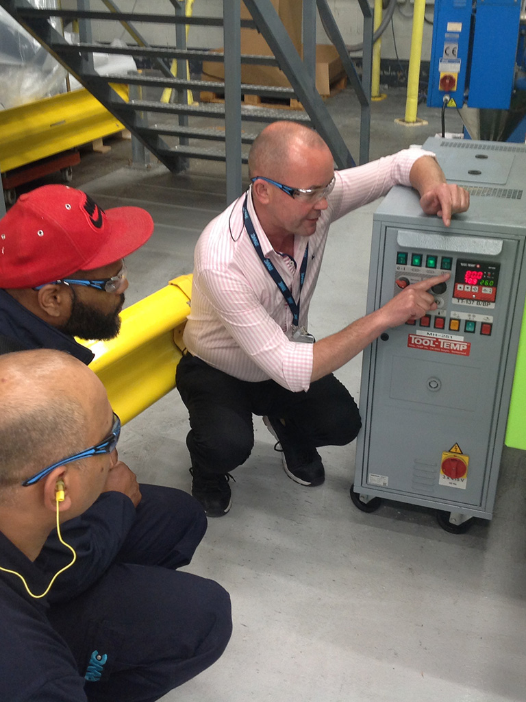 Instructor showing how injection moulding machine works